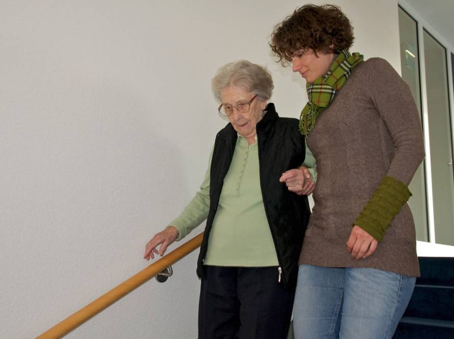 Begleitung Hannover – Betreuungskraft begleitet Seniorin beim sicheren Treppensteigen