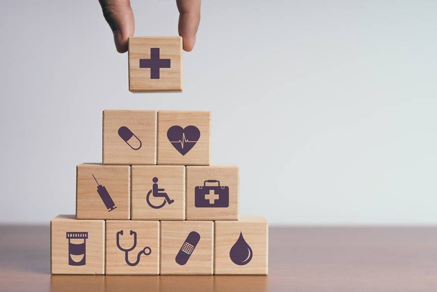 Behandlungspflege Hannover – Symbole für medizinische Versorgung als Holzbausteine dargestellt